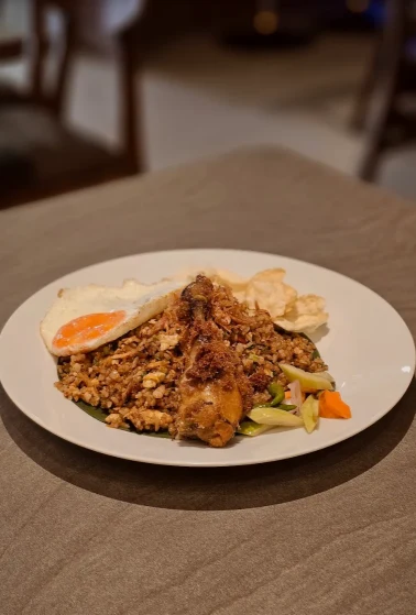 Hidangan nasi goreng dengan telur dan pelengkap di Plain Sight